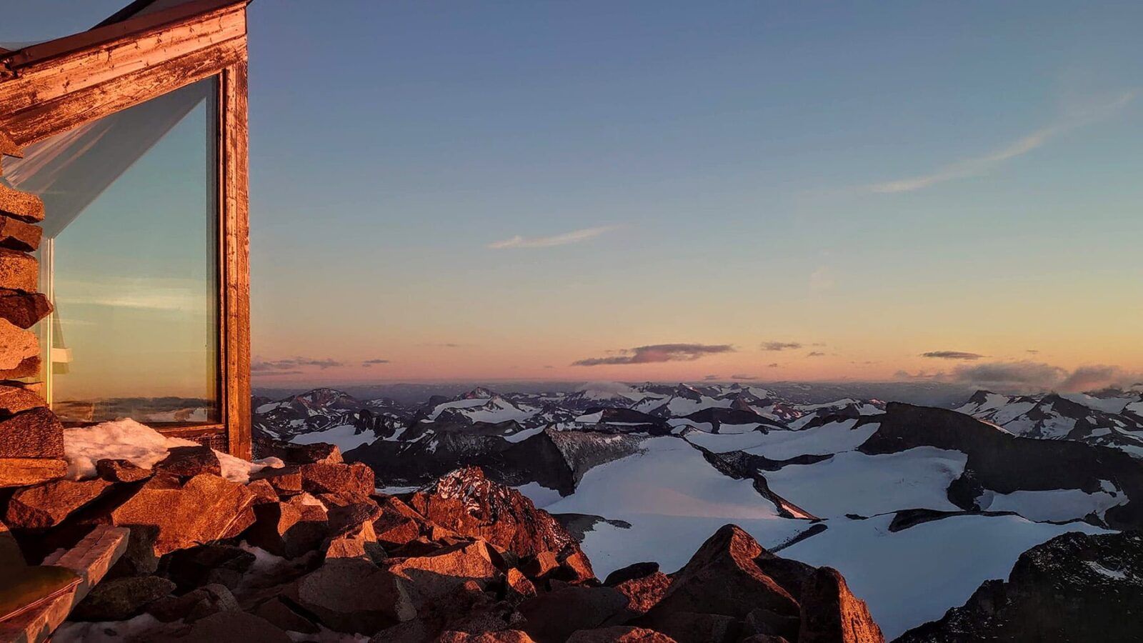 På toppen av Norges høyeste fjell, Galdhøpiggen i solnedgang.